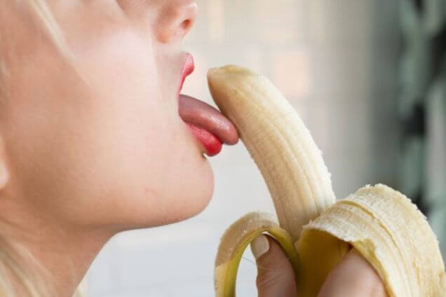 Une femme suce une banane